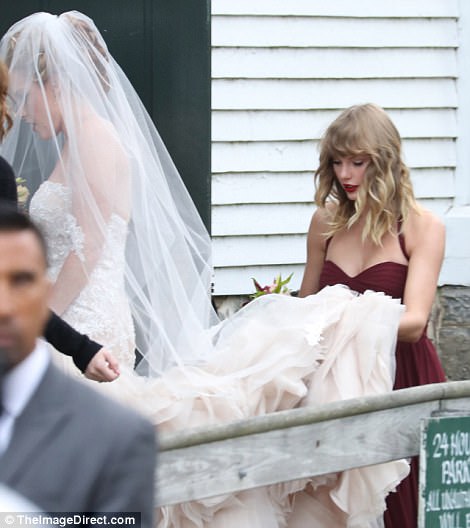 Let's do this! Taylor certainly fulfilled her bridesmaid duties as she happily carried Abigail's train for her, as she headed inside