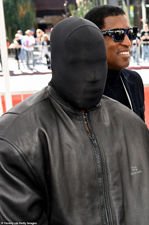 The rapper, 46, who along with wife Bianca Censori, 29, has shocked with his recent fashion displays , wore a black full-face covering