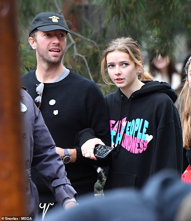 Fun: Fun: Chris Martin and girlfriend Dakota Johnson made a rare public appearance with his children (above with daughter Apple. 15) at Disneyland on Sunday to celebrate the singer's 43rd birthday