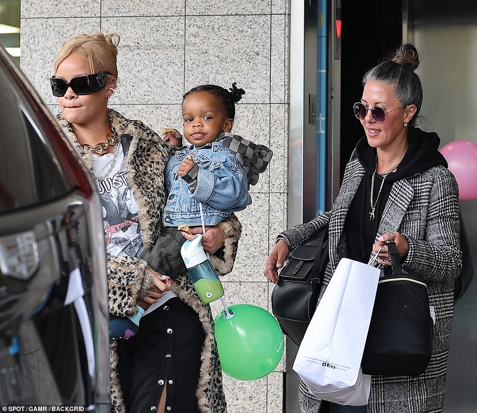 She had some help as an assistant carried a bag over her shoulder and had another one in her hand; there was also a white paper shopping bag