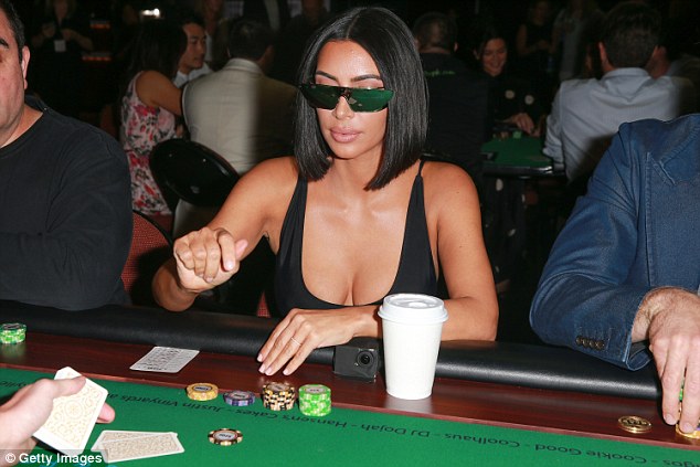 Putting it on the line: Kim kept her eyes shielded behind a pair of heavily tinted sunglasses as she played a game of poker at the charitable event 