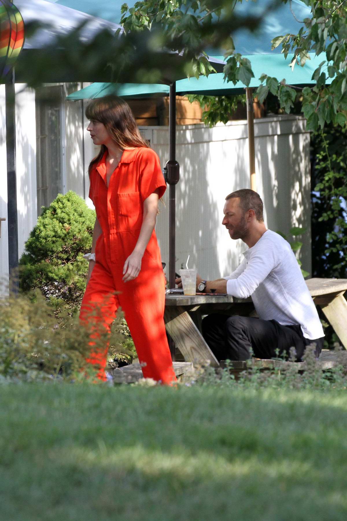 dakota johnson seen wearing an orange jumpsuit while out for lunch with  chris martin in the hampton's, new york-050819_2