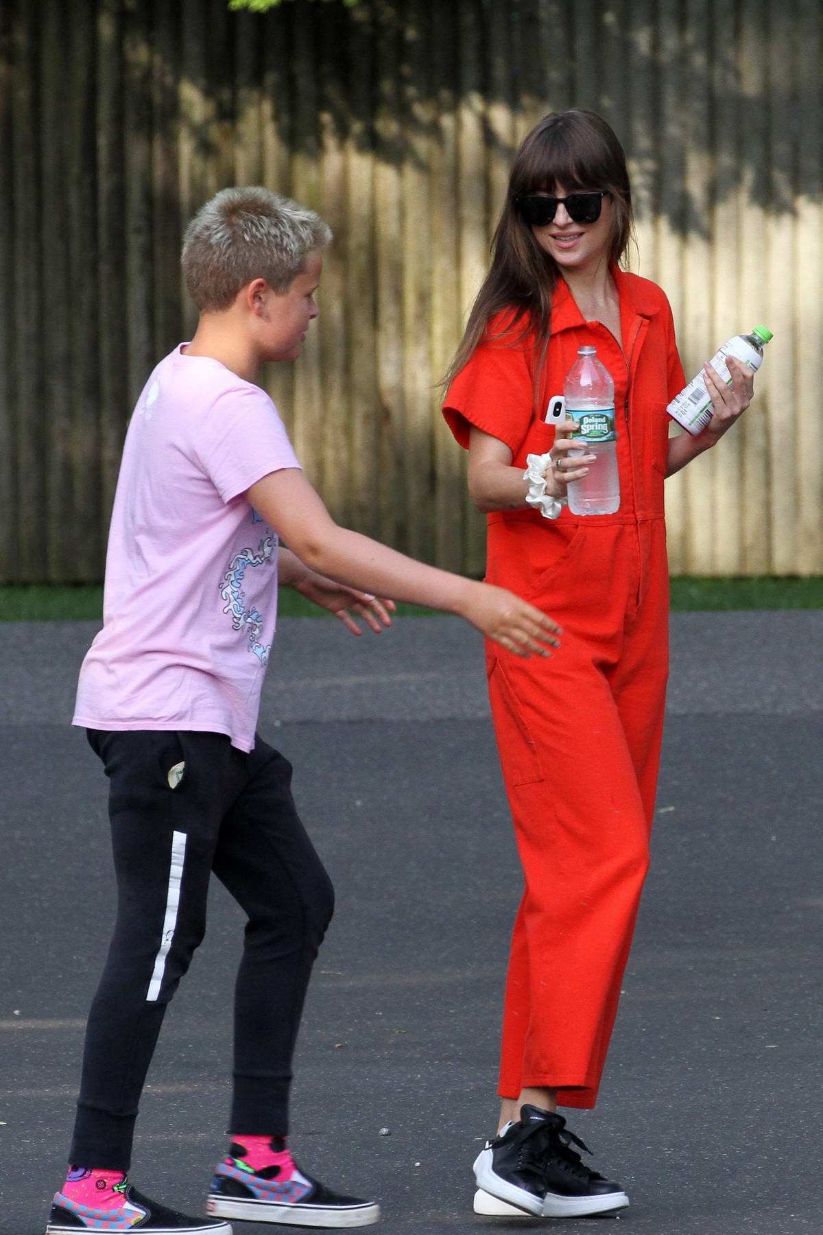 dakota johnson seen wearing an orange jumpsuit while out for lunch with  chris martin in the hampton's, new york-050819_11