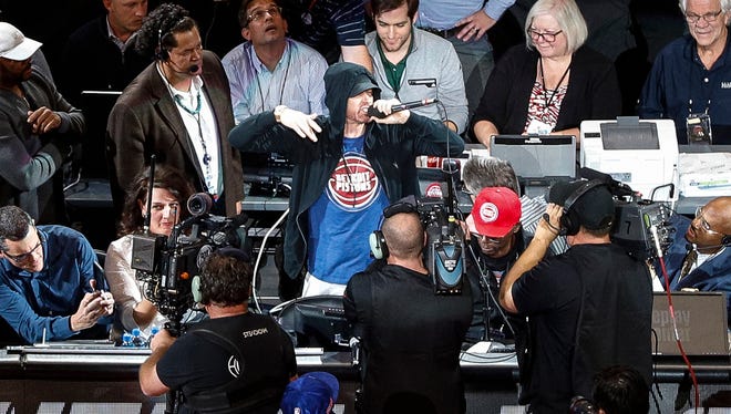 Eminem cheers the crowd before tipoff at the Detroit Pistons' home opener against the Charlotte Hornets at Little Caesars Arena in Detroit, Wednesday, Oct. 18, 2017.