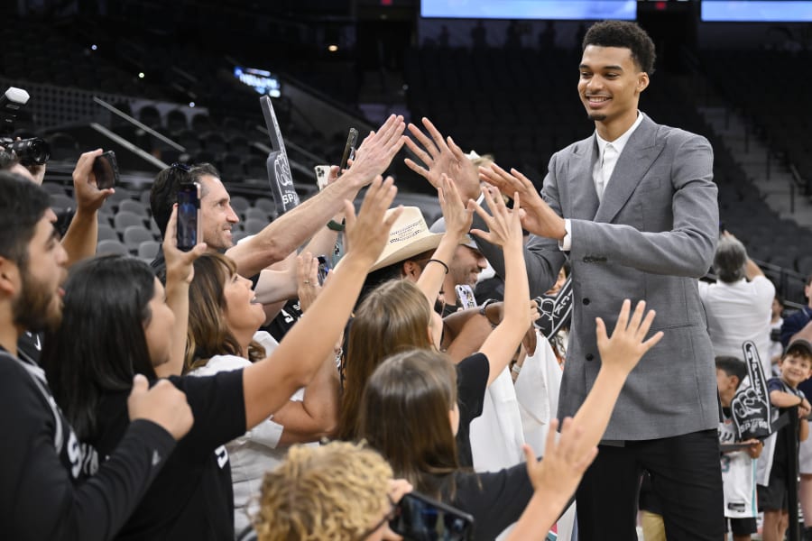 San Antonio Spurs' Victor Wembanyama, the No. 1 draft pick, greets fans before an NBA basketball press conference, Saturday, June 24, 2023, at the AT&T Center in San Antonio. (AP Photo/Darren Abate)