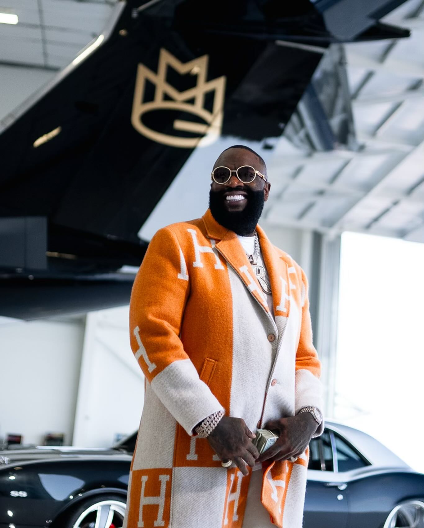 Photo shared by Rick Ross on April 13, 2024 tagging @ybmmg, @shulathedon, @officialbelaire, @originalbumbu, @officialrapsnacks, @theslipperysoap, @thrtdenim, @villonfrance, and @rickrosscarshow. May be an image of overcoat and turtleneck.
