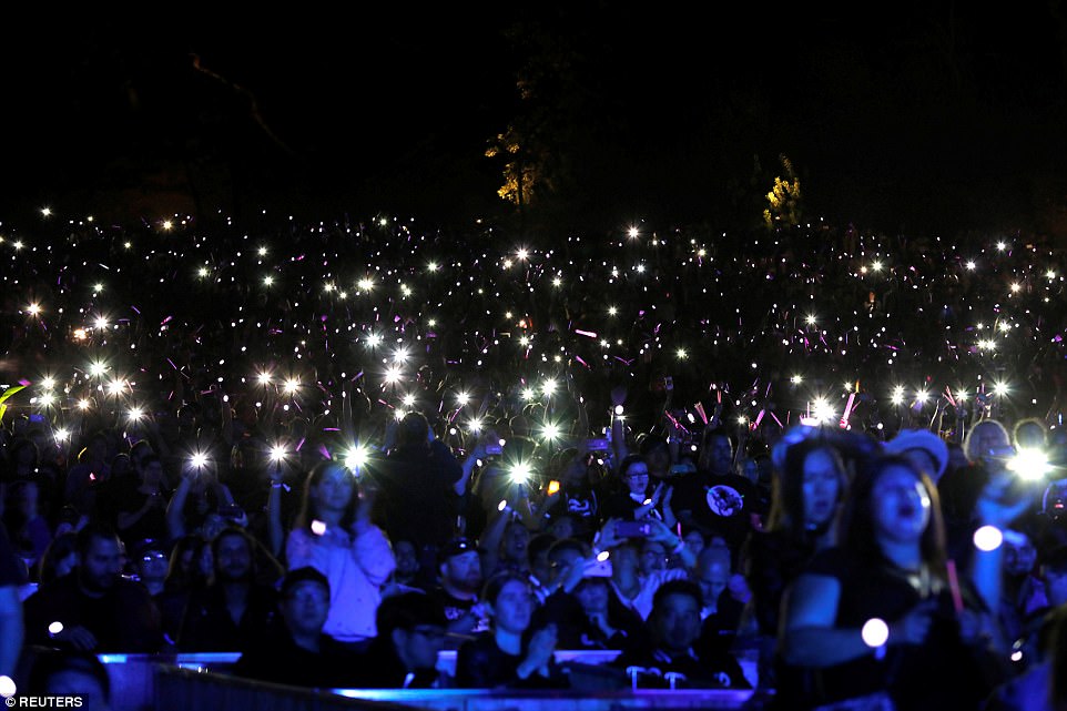 People shine lights from their mobile phones during the concert. More than 17,000 people attended the concert