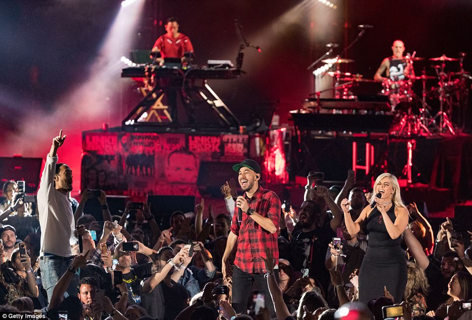 Shinoda is pictured performing with guests, including DJ Steve Aoki at left